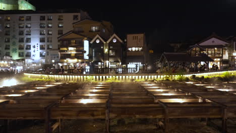 The-famous-Yubatake-in-Kusatsu-Onsen-Village-in-Gunma,-Japan-during-light-up-in-a-cool-summer-evening-with-hot-steam-rising