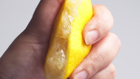 Hand-squeezes-fresh-natural-juice-out-of-the-lemon