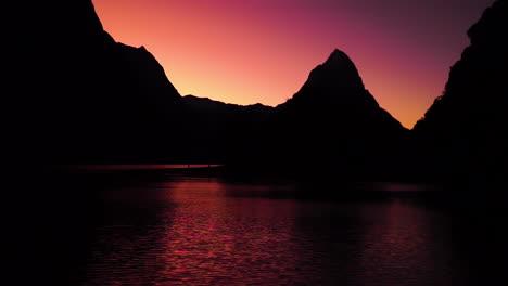 Silhouette-of-Mitre-Peak-and-Mount-Pembroke-at-dramatic-sunset,-Milford-Sound