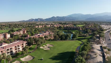 Aerial-descending-and-panning-shot-of-a-bright-golf-course-at-a-luxury-resort-in-Palm-Desert