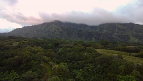 Cinematic-nature-aerial-view-of-green-mountains-under-tropical-rain-clouds-at-beautiful-sunrise-on-Kauai-Hawaii-island-Dramatic-epic-nature-aerial-view-of-Rainforest-Tropical-jungle-of-Kauai