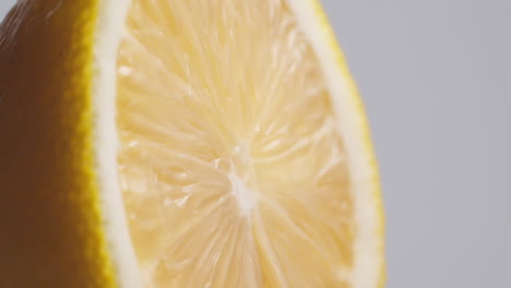 Slow-Motion-Macro-Shot-of-Flowing-Water-from-Lemon-Slice-on-white-Background