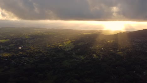 Golden-sunshine-glowing-on-horizon-at-beautiful-sunrise-on-Kauai-Hawaii-island-under-tropical-rain-clouds