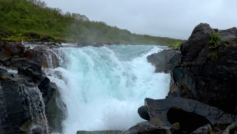 Fluss-Mit-Einem-Mächtigen-Wasserfall-In-Der-Nähe-Des-Waldes-Und-Zwischen-Den-Schwarzen-Felsen
