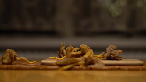 cinematic-shot-of-funnel-funnel-chanterelle-mushroom-falling-down-on-a-chopping-block