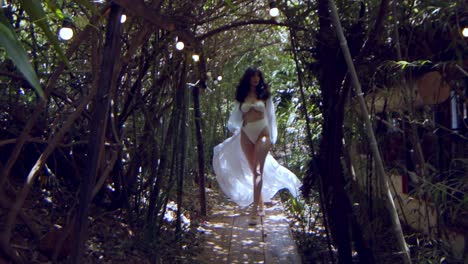 Gorgeous-model-in-a-white-bikini-and-white-dress-walks-through-a-jungle-in-slow-motion