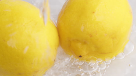 Drops-of-water-flow-down-to-yellow-lemons-in-Slow-motion