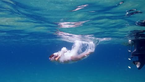 Erstaunliche-Unterwasseraufnahmen-Von-Rothaarigen-Kleinen-Mädchen,-Die-Vom-Motorboot-In-Kristallklarem,-Tiefblauem-Meerwasser-Mit-Tauchermaske-Tauchen