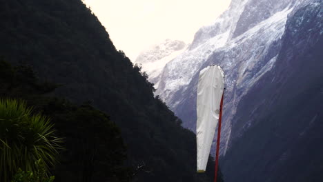 Wind-sock-on-a-snowy-cliff-mountain-view,-scenic-New-Zealand's-landscape