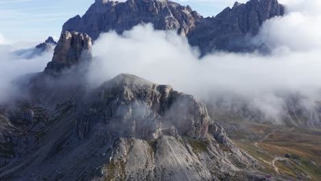 Torre-Di-Toblin-mountain-peak-surrounded-by-clouds-in-Dolomites,-wide-aerial-landscape-view