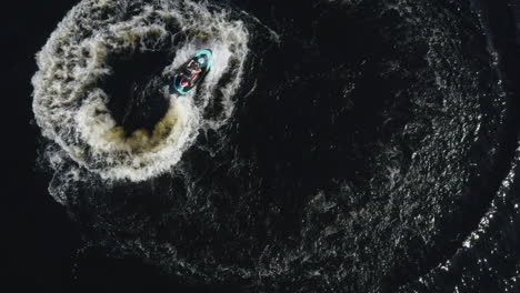 Aerial-top-down-view-of-a-young-male-on-a-jet-ski-driving-in-circles-in-the-water-in-Sweden