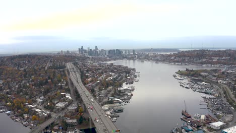 Wide-establishing-drone-shot-of-Lake-Union-passing-underneath-the-I-5-bridge-in-Seattle