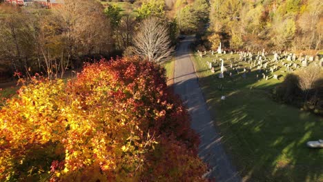 New-England-in-fall,-aerial-over-sugar-maples-and-graveyard-in-autumn-in-east-orange-vermont