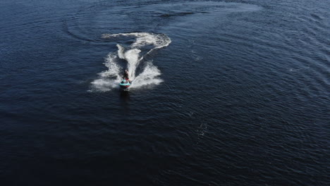 Aerial-view-of-a-young-man-enjoying-life-while-riding-on-a-jet-ski-in-a-river-in-Sweden