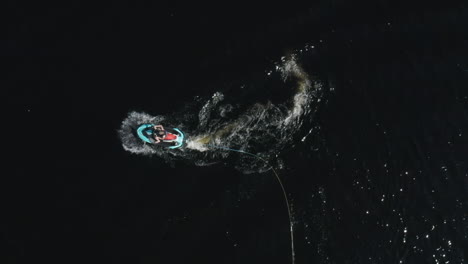 Aerial-top-view-of-a-young-man-on-a-speedy-jetski-in-deep-dark-water-in-Sweden