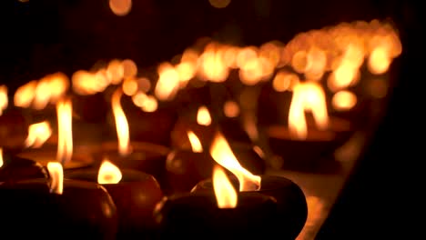Close-up-view-of-oil-candles-burning-at-night