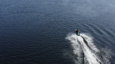 Aerial-view-of-a-young-man-riding-on-a-jet-ski-very-fast-on-the-water-in-Sweden