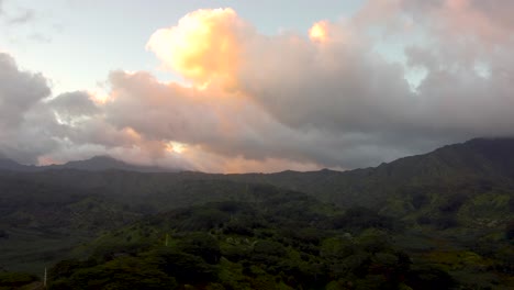 Cinematic-aerial-flyover-revealing-lush-green-rainforest,-rivers,-mountains-and-streams-during-sunset-with-yellow-clouds