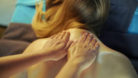 Der-Masseur-Massiert-Den-Rücken-Des-Mädchens-Mit-Massageöl-Von-Unten-Nach-Oben