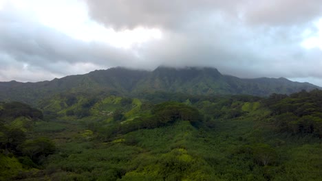 Sobrevuelo-Aéreo-Cinematográfico-Que-Revela-Una-Exuberante-Selva-Tropical,-Ríos-Y-Montañas-Verdes-Con-Nubes-Al-Atardecer