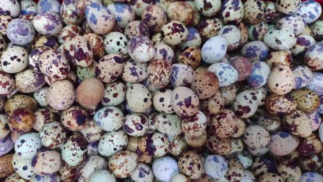 Top-shot-of-a-pile-of-quail-eggs-in-a-basket-for-sale