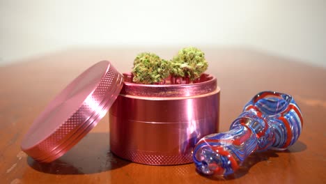 Tilt-down-to-pipe-next-to-grinder-with-cannabis-in-it