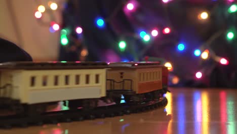 Close-Up-of-Toy-Train-Going-Around-Decorated-Christmas-Tree