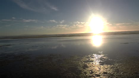 Kamerafahrt-Von-Links-Nach-Rechts-An-Einem-Strand-Direkt-über-Der-Lagune-Mit-Sonnenuntergang-Im-Hintergrund