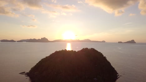 Beautiful-sunset-reflecting-the-ocean-in-Tropical-island-of-Philippines,-El-Nido,-Palawan-with-silhouette-limestone-cliffs-on-background