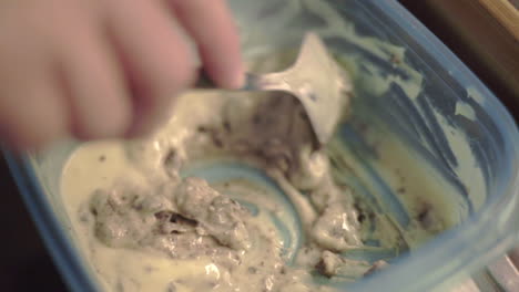 Mixing-Cookie-Pancake-Batter-In-A-Plastic-Container-With-A-Spoon---Closeup-Shot