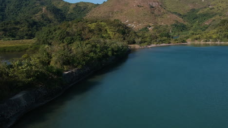 Aerial-View-Wide-shot-of-Reservoir-in-Hong-Kong,-Mountains-in-Background