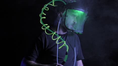 Tilt-Up,-Man-vapes-or-smokes-from-neon-coiled-tube-in-clear-helmet