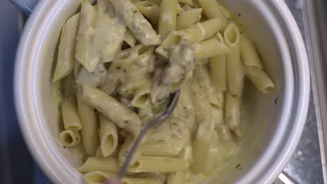 Overhead-view:-cook-and-stir-vegan-cream-cheese-penne-pasta-together-in-bowl