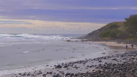 Surfers-On-The-Shore-Walking-Towards-The-Sea-In-Crescent-Head---Best-Surfing-Spot-In-New-South-Wales,-Australia---wide-shot