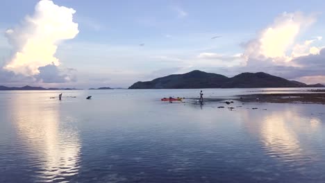 Aerial-orbit-motion-of-Fisherman-walking-on-low-tide-delivering-stuff-at-Palawan,-Philippines