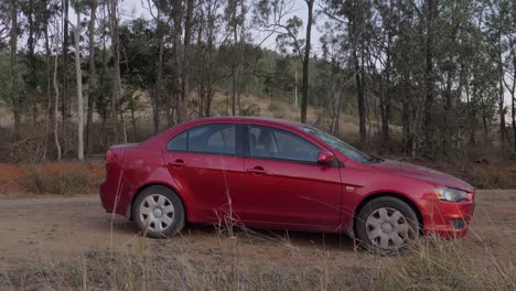 Un-Coche-Mitsubishi-Lancer-Rojo-Desgastado-Abandonado-En-Una-Tierra-Rural-En-Australia---Tiro-Completo