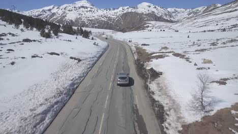 Car-Driving-on-Countryside-Road-With-Mountains-During-Winter,-Aerial-Tracking
