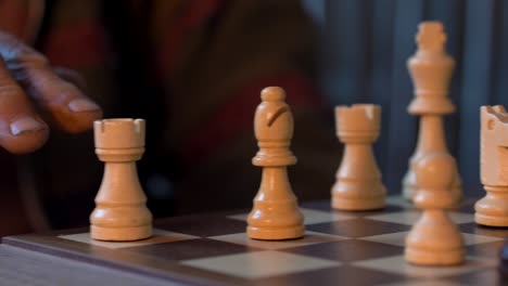 Man-Moves-White-Bishop-On-Chessboard---close-up-shot