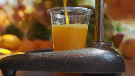 Shot-of-orange-juice-squeezed-in-orange-juicer