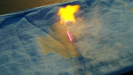 Denim-Fabrik,-Die-Laserstrahlen-Verwendet,-Um-Design-Auf-Blue-Jeans-Zu-Machen