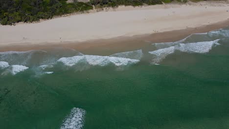 Crystal-Clear-Blue-Sea-With-Foamy-Waves-Splashing-On-The-Shore---Aerial-View-Of-Fingal-Head-Beach-In-New-South-Wales,-Australia---panning-drone-shot