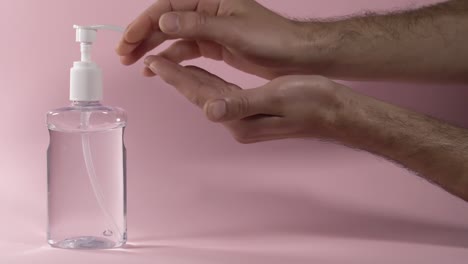 applying-slippery-damp-lubricant-gel-with-pink-background,-slow-motion