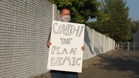 Anti-Covid-Demonstrant-Mit-Netzmaske---Planen-Sie-Demische-Kamerafahrt