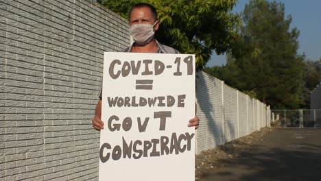 Anti-Covid-Protestler-Mit-Netzmaske---Weltweite-Verschwörung