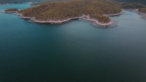 Calm-Waters-Of-Advancetown-Lake-Near-Hinze-Dam---Lush-Mountain-Surrounded-By-Dead-Trees---Gold-Coast,-Queensland,-Australia