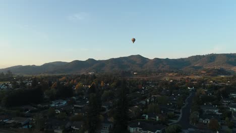 Stetige-Luftaufnahme-Eines-Heißluftballons,-Der-über-Der-Stadt-Aufsteigt
