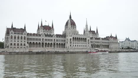 Budapest-Parliament-from-the-river-side,-with-a-boat-on-the-front,-filmed-from-a-boat