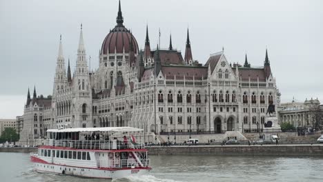 Budapester-Parlament-Von-Der-Flussseite,-Mit-Einem-Boot-Auf-Der-Vorderseite,-Gefilmt-Von-Einem-Boot
