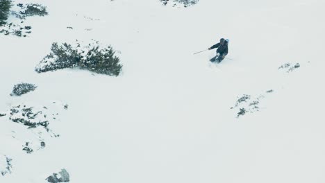 slow-motion-close-view-of-a-man-off-piste-freeride-skiing-through-powder,-whilst-beautifully-turning-on-a-cold-winter-day