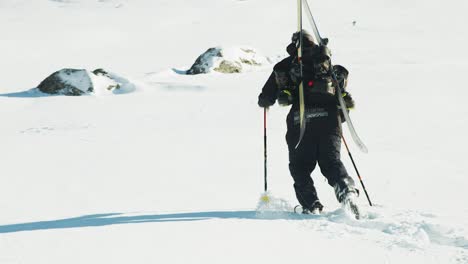 Hombre-Caminando-Con-Esquís-En-La-Espalda-A-Través-De-La-Nieve-Profunda-En-Un-Soleado-Día-En-Las-Montañas-Francesas